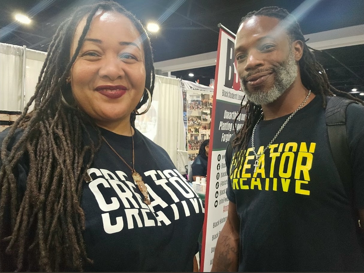 Madison Sinclair and T² standing together, both wearing navy Creator Creative shirts
