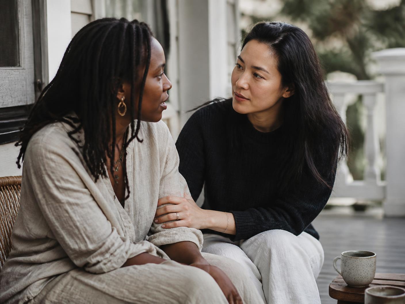 Two people in deep conversation on a couch in afternoon light